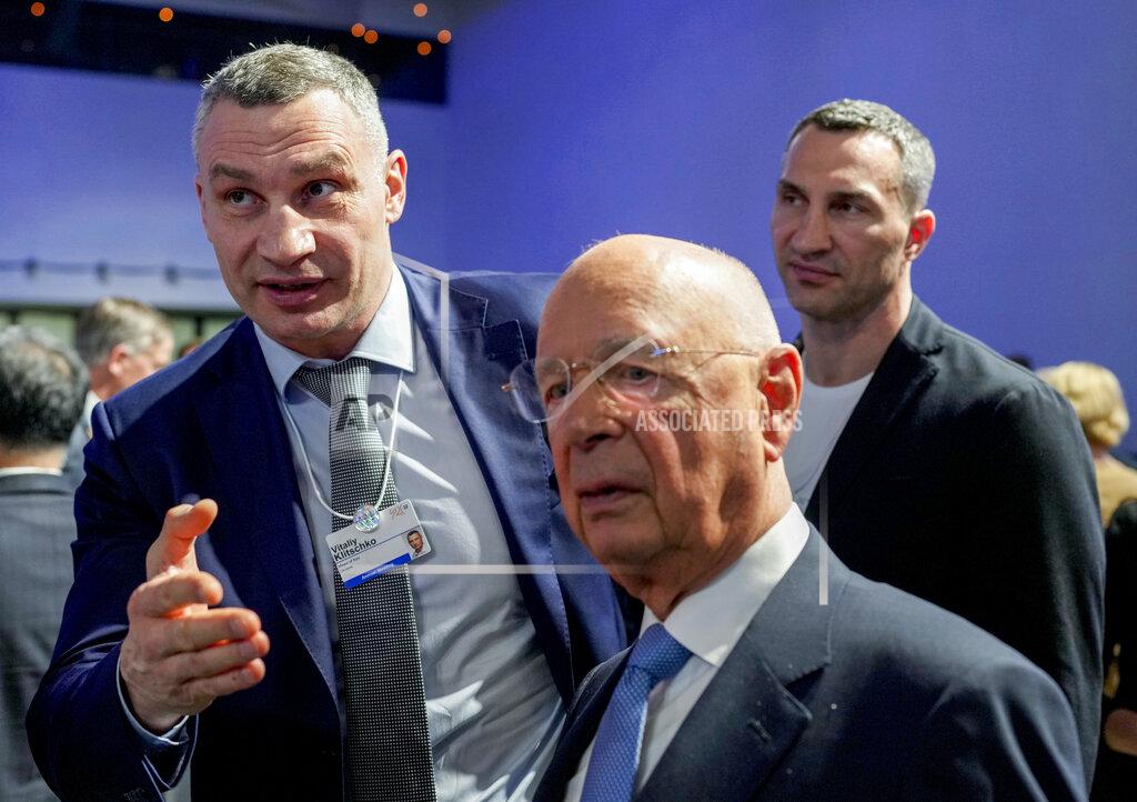 Markus Schreiber Kyiv Mayor Vitali Klitschko, left, and his brother Wladimir talk to Forum founder Klaus Schwab during the World Economic Forum in Davos, Switzerland, Monday, May 23, 2022. The annual meeting of the World Economic Forum is taking place in Davos from May 22 until May 26, 2022. (AP Photo/Markus Schreiber)