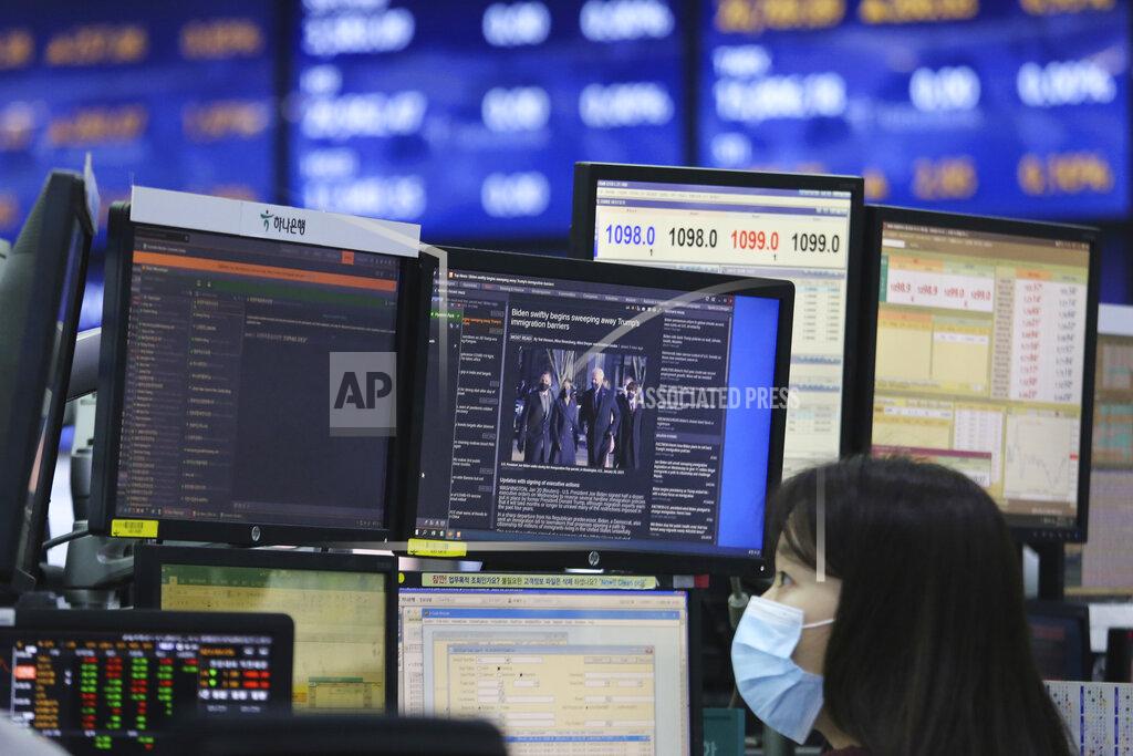 Ahn Young-Joon A screen shows a news report about U.S. President Joe Biden's inauguration as a currency trader works at the foreign exchange dealing room of the KEB Hana Bank headquarters in Seoul, South Korea, Thursday, Jan. 21, 2021. (AP Photo/Ahn Young-joon)