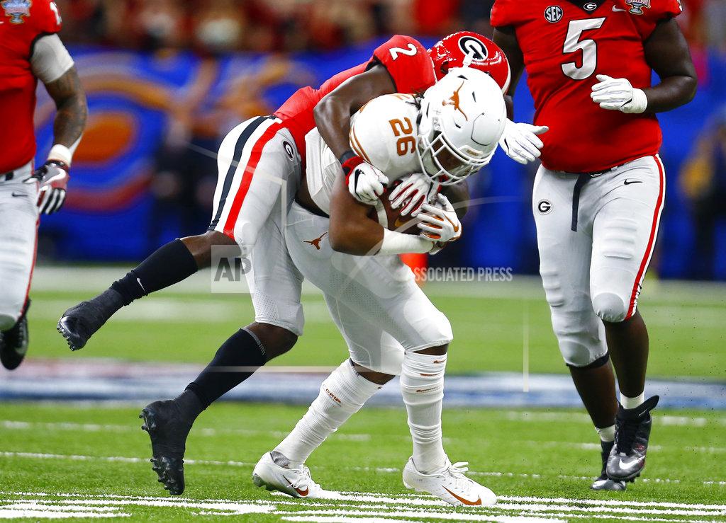 Butch Dill Texas running back Keaontay Ingram (26) is stopped by Georgia defensive back Richard LeCounte (2) during the first half of the Sugar Bowl NCAA college football game in New Orleans, Tuesday, Jan. 1, 2019. (AP Photo/Butch Dill)