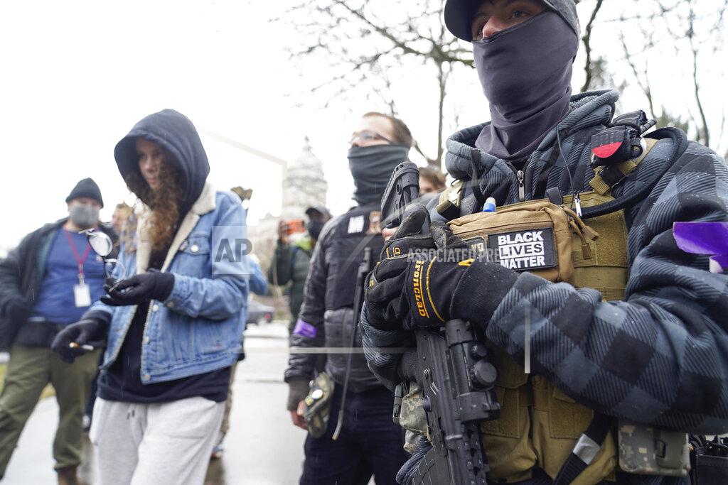 Bryan Woolston Black Lives Matter activists carrying semi-automatic weapons walk outside at the Capitol building in Frankfort, Ky., Wednesday, Jan 17, 2021. The Capitol, the Capitol complex, and surrounding grounds have been closed. (AP Photo/Bryan Woolston)