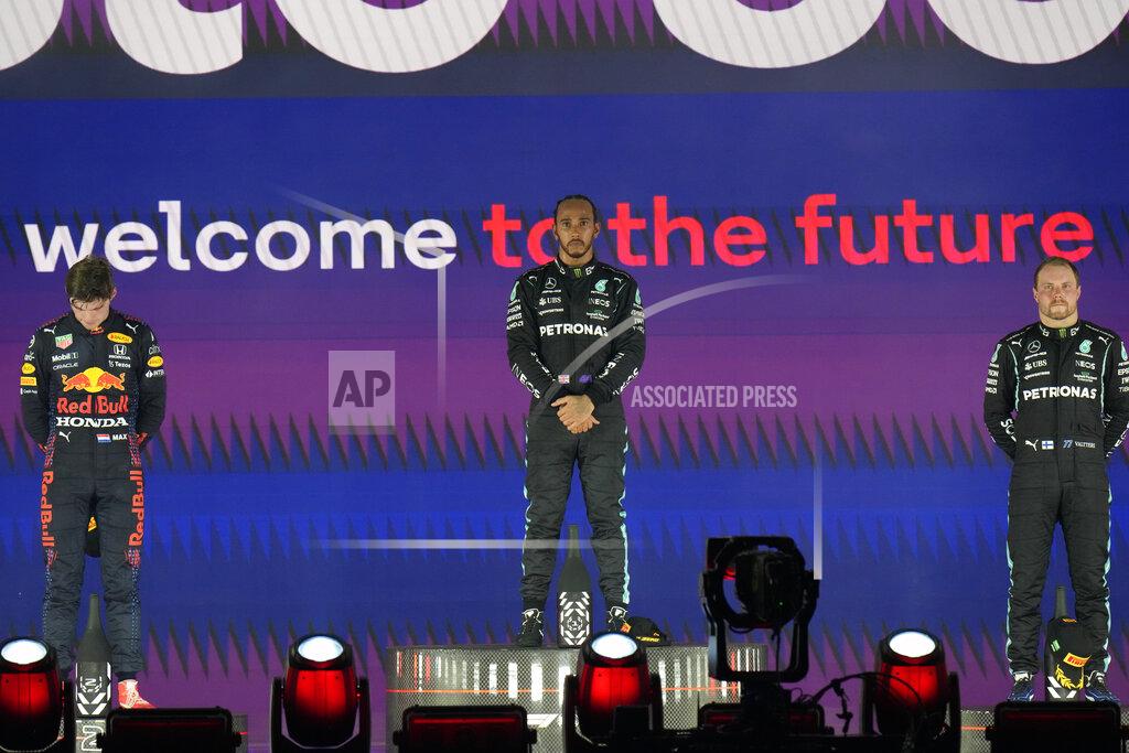 Hassan Ammar Mercedes driver Lewis Hamilton of Britain stand at the podium after winning the Formula One Saudi Arabian Grand Prix in Jiddah, Sunday, Dec. 5, 2021. Left is second placed Red Bull driver Max Verstappen of the Netherlands and Ron the right is third, Mercedes driver Valtteri Bottas of Finland. (AP Photo/Hassan Ammar)