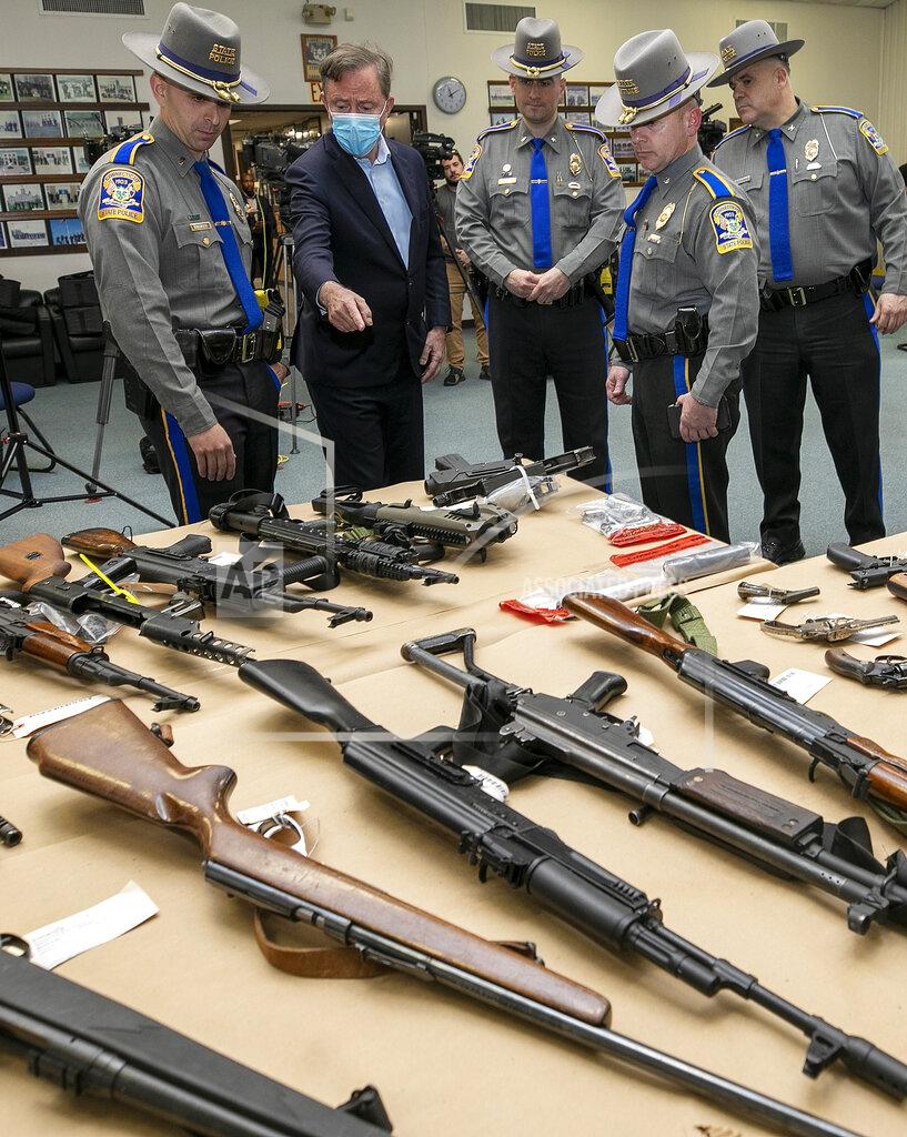 Dave Zajac FILE - Gov. Ned Lamont and state troopers view dozens of assault weapons, rifles and handguns displayed on a table prior to a press conference at the Connecticut Forensic Science Laboratory in Meriden, Conn., Thursday, April 14, 2022. In Connecticut, gun violence legislation supported by both Democrats and Republicans swiftly followed after 20 children and six staff members were shot and killed at Sandy Hook Elementary School in 2012. But additional gun control measures stalled this year in the Democratic-led General Assembly, in large part because of a short legislative session and threats by Republicans to hold up legislation through a filibuster. (Dave Zajac/Record-Journal via AP, File)