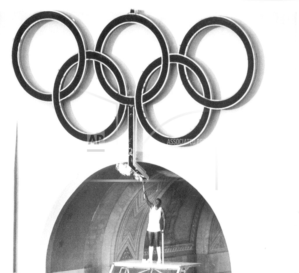 Uncredited FILE - In this July 28, 1984, file photo, Rafer Johnson, winner of the gold medal for the decathlon in 1960, lights the Olympic torch during opening ceremonies of the Olympic Games in Los Angeles. Rafer Johnson, who won the decathlon at the 1960 Rome Olympics and helped subdue Robert F. Kennedy's assassin in 1968, died Wednesday, Dec. 2, 2020. He was 86. He died at his home in the Sherman Oaks section of Los Angeles, according to family friend Michael Roth. (AP Photo/FIle)