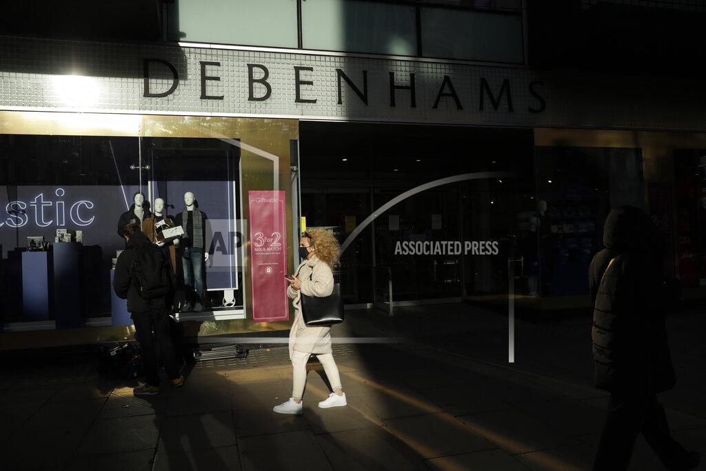 Matt Dunham A woman wearing a face mask walks past the Debenhams flagship department store on Oxford Street, during England's second coronavirus lockdown in London, Tuesday, Dec. 1, 2020. In another dark day for the British retailing industry, Debenhams said Tuesday it will start liquidating its business after a potential buyer of the company pulled out, a move that looks like it will cost 12,000 workers their jobs. (AP Photo/Matt Dunham)
