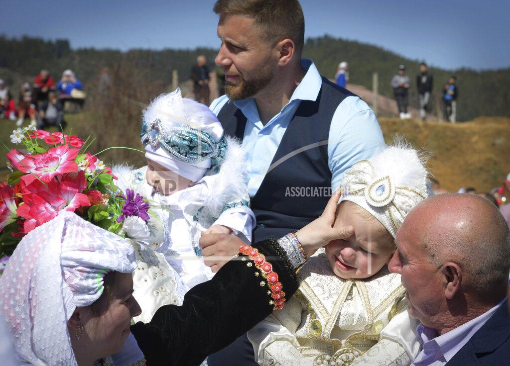 Jordan Simeonov Ismail Atipov holds his son as they take part in a mass circumcision ceremony in the village of Ribnovo, Bulgaria, Sunday, April 11, 2021. Despite the dangers associated with COVID-19 and government calls to avoid large gatherings, Hundreds of people flocked to the tiny village of Ribnovo in southwestern Bulgaria for a four-day festival of feasting, music and the ritual of circumcision which is considered by Muslims a religious duty and essential part of a man's identity. (AP Photo/Jordan Simeonov)