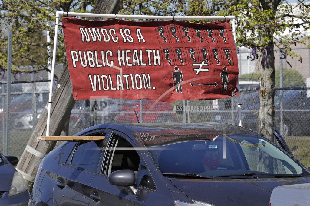 Ted S. Warren A sign protests social distancing conditions at the Northwest Detention Center during a car-based protest, Wednesday, April 15, 2020, in Tacoma, Wash. The facility is privately operated on behalf of the U.S. Immigration and Customs Enforcement agency, and organizers said they were showing support for detainees inside who were taking part in a hunger strike to protest conditions they say are inadequate to protect detainees from the spread of the coronavirus. (AP Photo/Ted S. Warren)