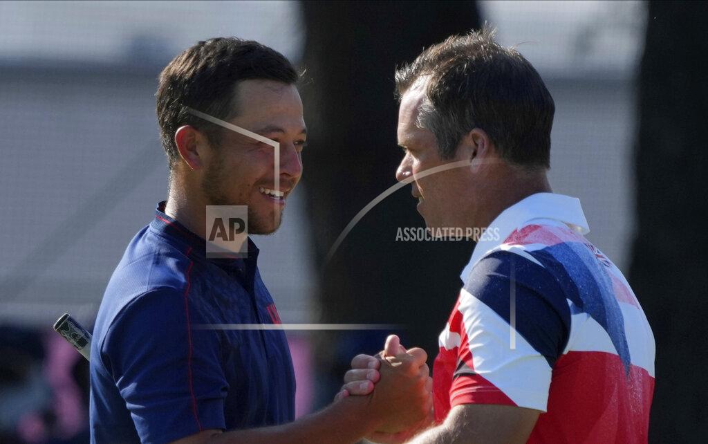 Xander Shauffele of United States, left, is congratulated by Paul Casey of Great Britain after winning Gold in the Men's Golf event at the 2020 Summer Olympics on Sunday, Aug. 1, 2021, in Kawagoe, Japan. (AP Photo/Andy Wong)