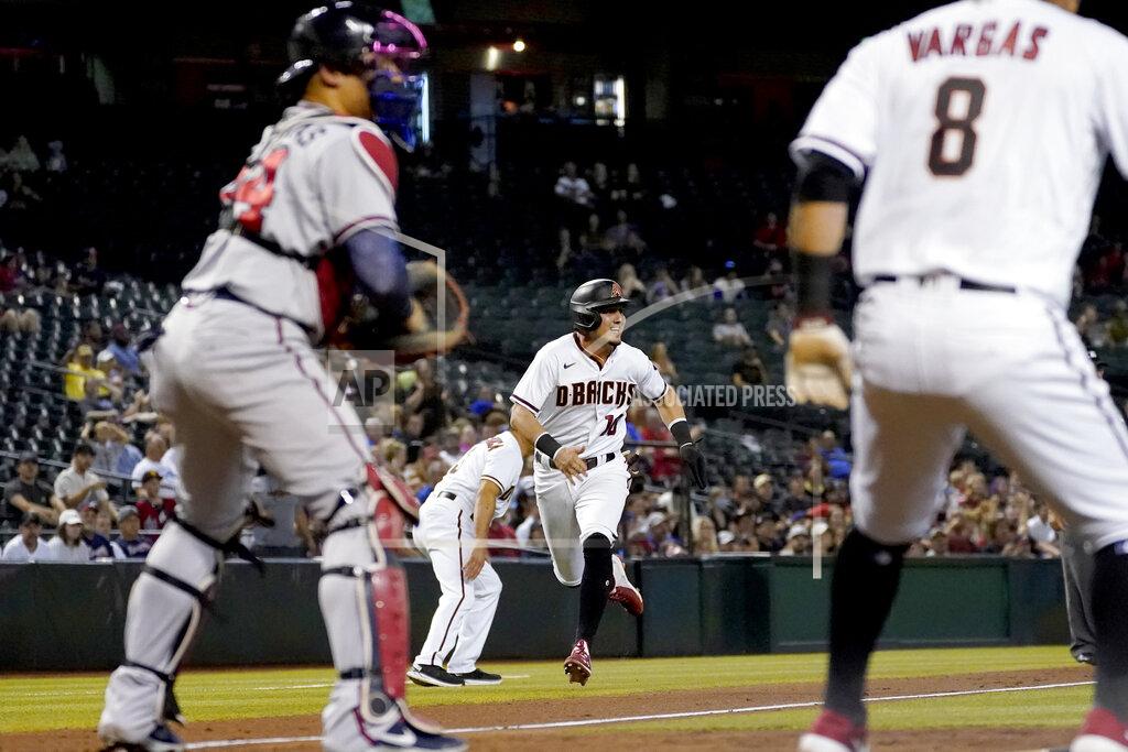 Matt York Arizona Diamondbacks' Josh Rojas scores on a double by Ketel Marte as Atlanta Braves catcher William Contreras, left, waits for the throw during the third inning of a baseball game, Monday, Sept. 20, 2021, in Phoenix. (AP Photo/Matt York)