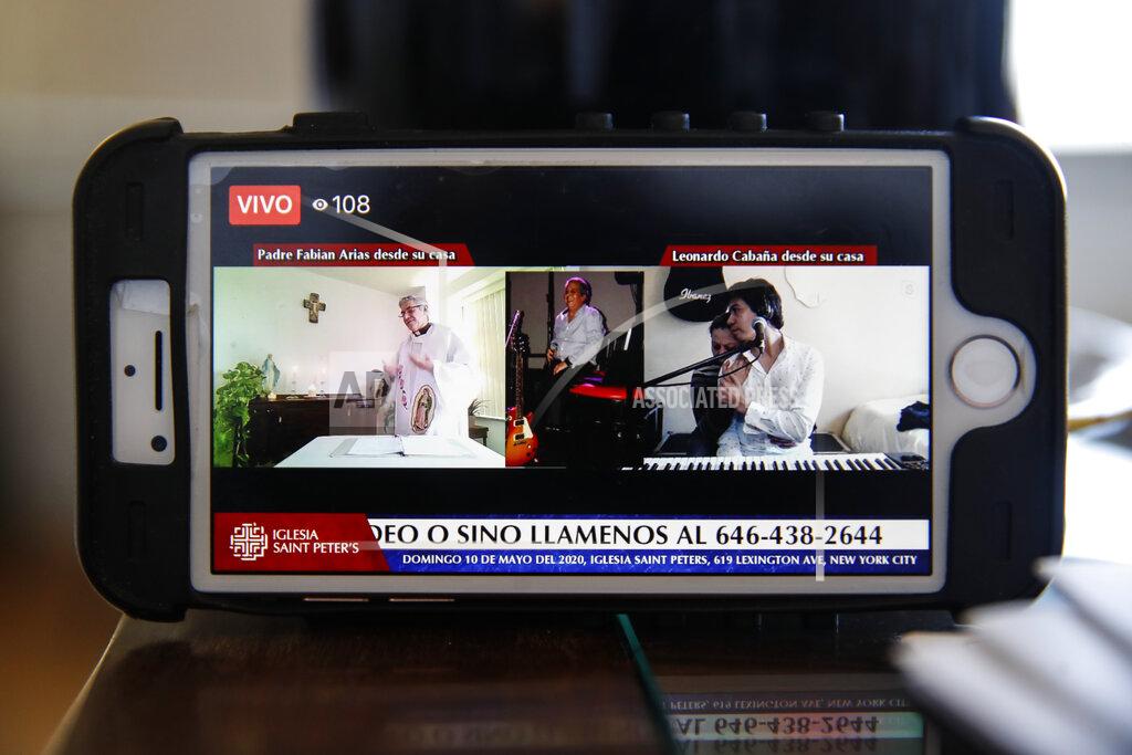 John Minchillo Leonardo Cabana, right, hugs his sister after he sings about his father Hector Cabana who died of COVID-19 during a Sunday service provided via internet livestream by Fabian Arias, a Lutheran pastor with Saint Peter's Church in Manhattan, at his home, Sunday, May 10, 2020, in the Bronx borough of New York. (AP Photo/John Minchillo)