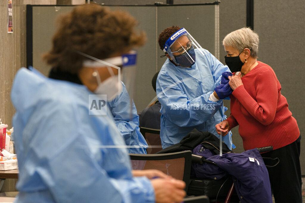 Jacquelyn Martin In this Thursday, Feb. 11, 2021, photo Charlotte Lee, 78, of Washington, right, prepares to receive her second dose of the COVID-19 vaccine at a clinic at Howard University, in Washington. "I have underlying conditions so I had no hesitation in getting this vaccine," says Lee, who signed up at Howard after being unsuccessful at using the city's vaccination sign-up site. (AP Photo/Jacquelyn Martin)