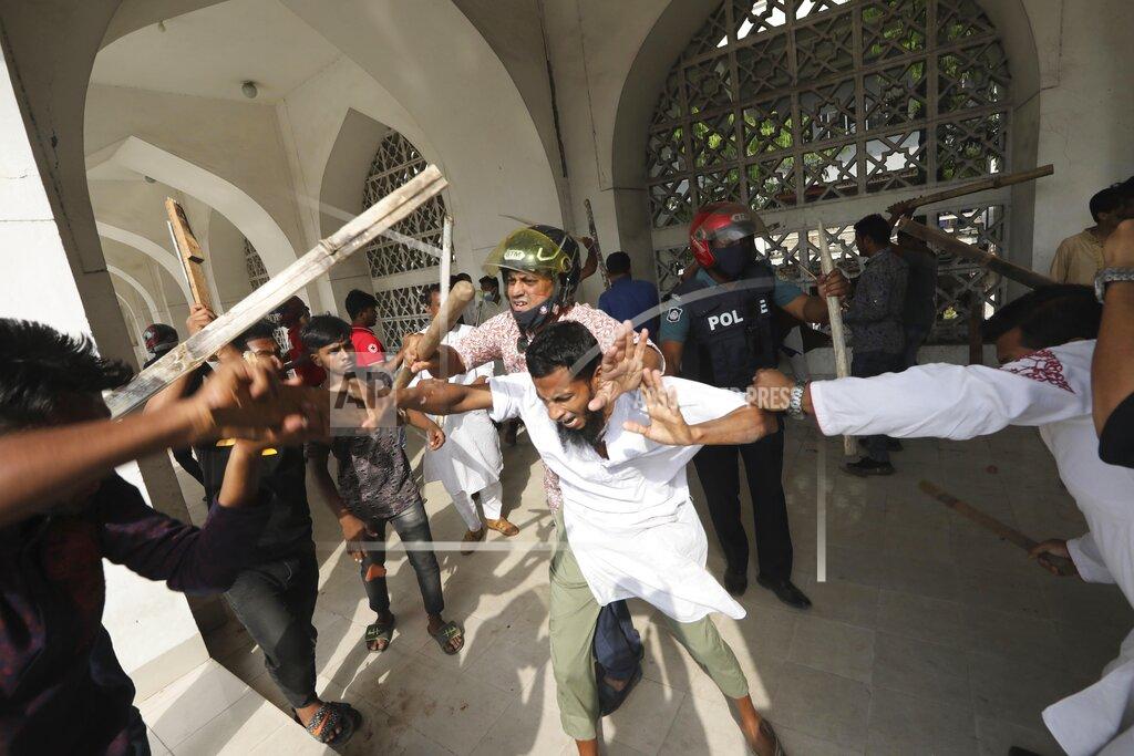 Mahmud Hossain Opu Two factions of protestors clash after Friday prayers at Baitul Mokarram mosque in Dhaka, Bangladesh, Friday, March 26, 2021. Witnesses said violent clashes broke out after one faction of protesters began waving their shoes as a sign of disrespect to Indian Prime Minister Narendra Modi, and another group tried to stop them. Local media said the protesters who tried to stop the shoe-waving are aligned with the ruling Awami League party. The party criticized the other protest faction for attempting to create chaos in the country during Modi’s visit. (AP Photo/Mahmud Hossain Opu)