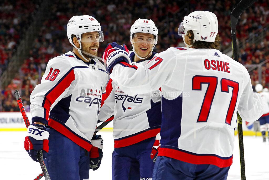 Washington Capitals' T.J. Oshie (77) celebrates his goal with teammate Chandler Stephenson (18) and Jakub Vrana (13) of Czech Republic during the first period of an NHL preseason hockey game against the Carolina Hurricanes, in Raleigh, N.C., Sunday, Sept. 29, 2019. (AP Photo/Karl B DeBlaker)