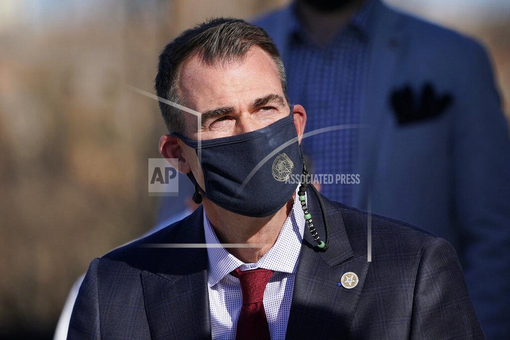 Sue Ogrocki Wearing a face mask, Oklahoma Gov. Kevin Stitt listens during a news conference Tuesday, Nov. 10, 2020, in Oklahoma City. Stitt and hospital officials in Oklahoma City joined in a news conference to, as Stitt said, plead with residents to voluntarily socially distance, wash hands and wear masks, but he again said he would not issue a statewide mask mandate. (AP Photo/Sue Ogrocki)