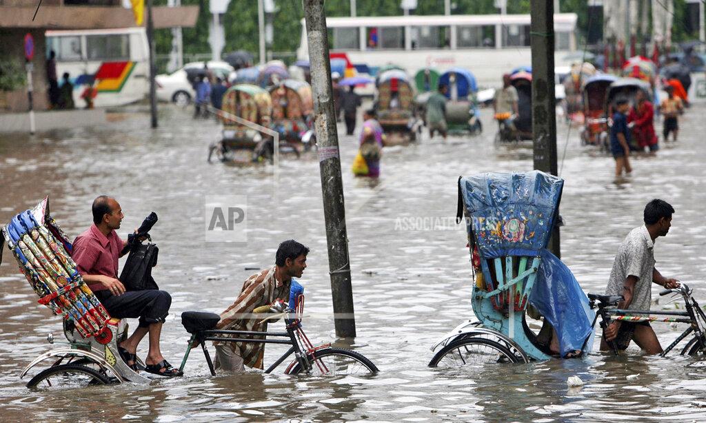 Pavel Rahman FILE - In this Tuesday, July 28, 2009 file photo, drivers pull their rickshaws carrying passengers through a flooded street in Dhaka, Bangladesh. Bangladesh plans to present its “climate prosperity plan” aimed at mitigating the effects of global warming on economic development at the forthcoming U.N. climate talks in Glasgow, Bangladeshi climate officer Abul Kalam Azad said in an interview with The Associated Press on Friday, Oct. 22, 2021. With most of its 160 million people tightly packed into low-lying areas along the Bay of Bengal, Bangladesh is considered especially prone to flooding, extreme weather and the loss of farmland to rising ocean levels. (AP Photo/Pavel Rahman, File)