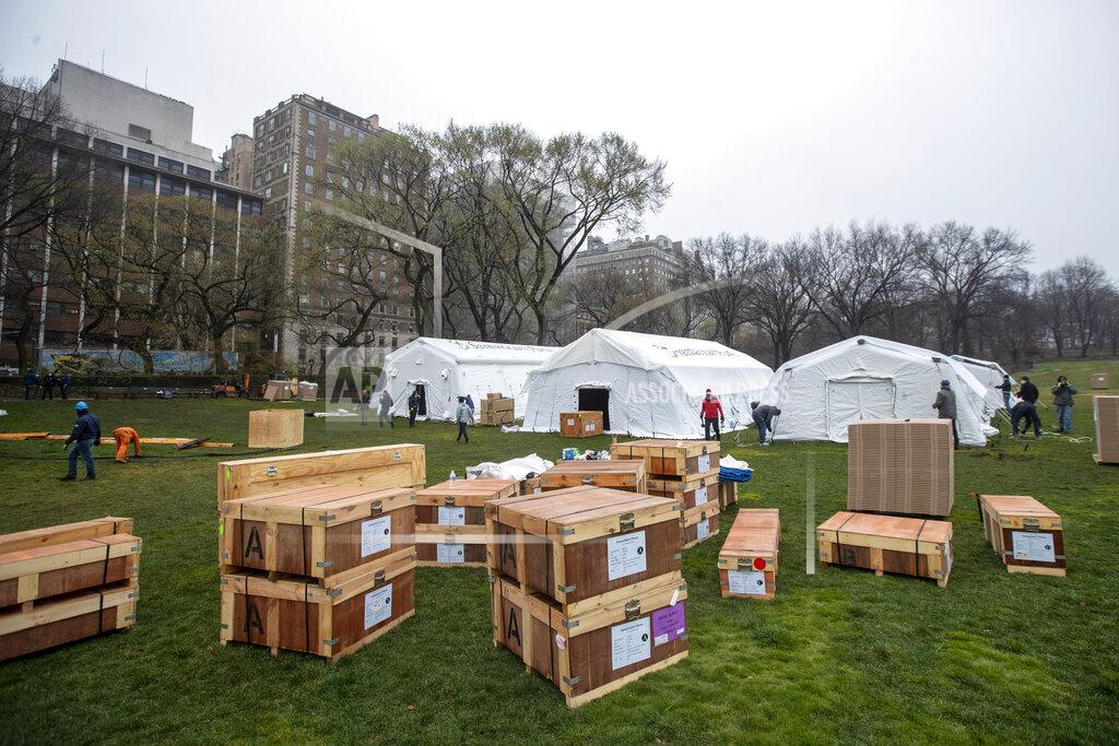 FILE - In this March 29, 2020, file photo, a Samaritan's Purse crew works on building an emergency field hospital equipped with a respiratory unit in New York's Central Park across from the Mount Sinai Hospital. Uncertainty in planning for the pandemic has left the globe dotted with dozens of barely used or unused temporary field hospitals. (AP Photo/Mary Altaffer)