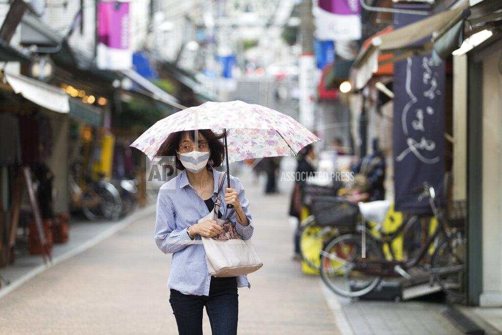 Hiro Komae A woman with a face mask walks through a shopping street in the rain in Tokyo on Thursday, Oct. 15, 2020. (AP Photo/Hiro Komae)
