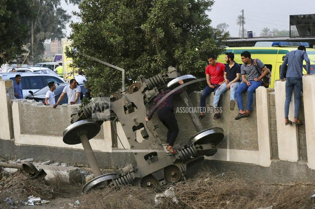 Fadel Dawood People gather at the site where a passenger train derailed injuring at least 100 people, near Banha, Qalyubia province, Egypt, Sunday, April 18, 2021. At least eight train wagons ran off the railway, the provincial governor's office said in a statement. (AP Photo/Fadel Dawood)