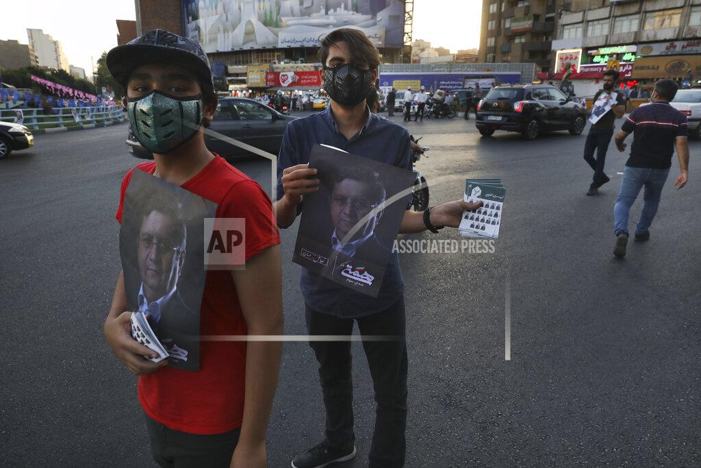 Vahid Salemi Supporters of Abdolnasser Hemmati, a presidential candidate in the June 18, elections, holds signs with his picture, during a street rally in Tehran, Iran, Tuesday, June 15, 2021. Hemmati, a prominent contender in Iran's presidential election appealed Tuesday for better economic and political relations with the West, his most extensive attempt yet to attract reformist voters just days ahead of the poll. (AP Photo/Vahid Salemi)