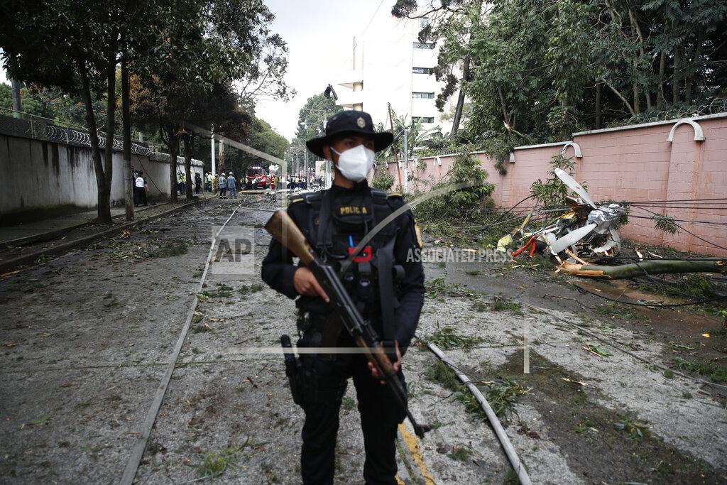 Moises Castillo A policeman stands guard at the area where a plane that crashed in Guatemala City, Sunday, Nov. 8, 2020. A plane crashed after taking off from Guatemala City's La Aurora Airport with humanitarian aid to the areas affected by the ETA storm. At least one person died in the accident, firefighters reported. (AP Photo/Moises Castillo)