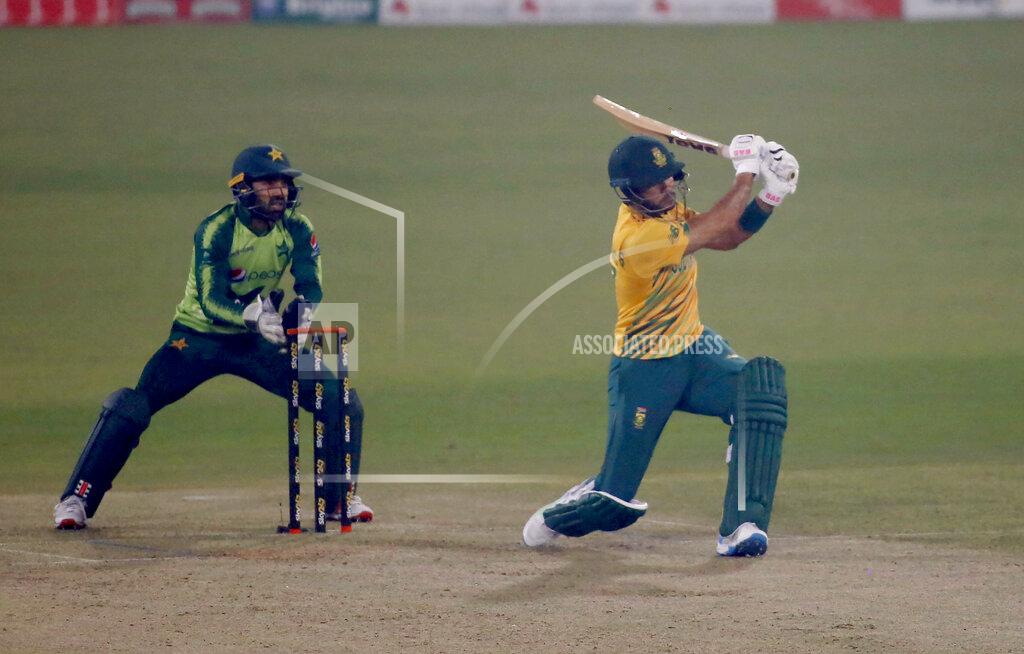 South Africa's Reeza Hendricks, right, follows the ball after playing a shot for six while Pakistan's Mohammad Rizwan watches during the 2nd Twenty20 cricket match between Pakistan and South Africa at the Gaddafi Stadium, in Lahore, Pakistan, Saturday, Feb. 13, 2021. (AP Photo/K.M. Chaudary)