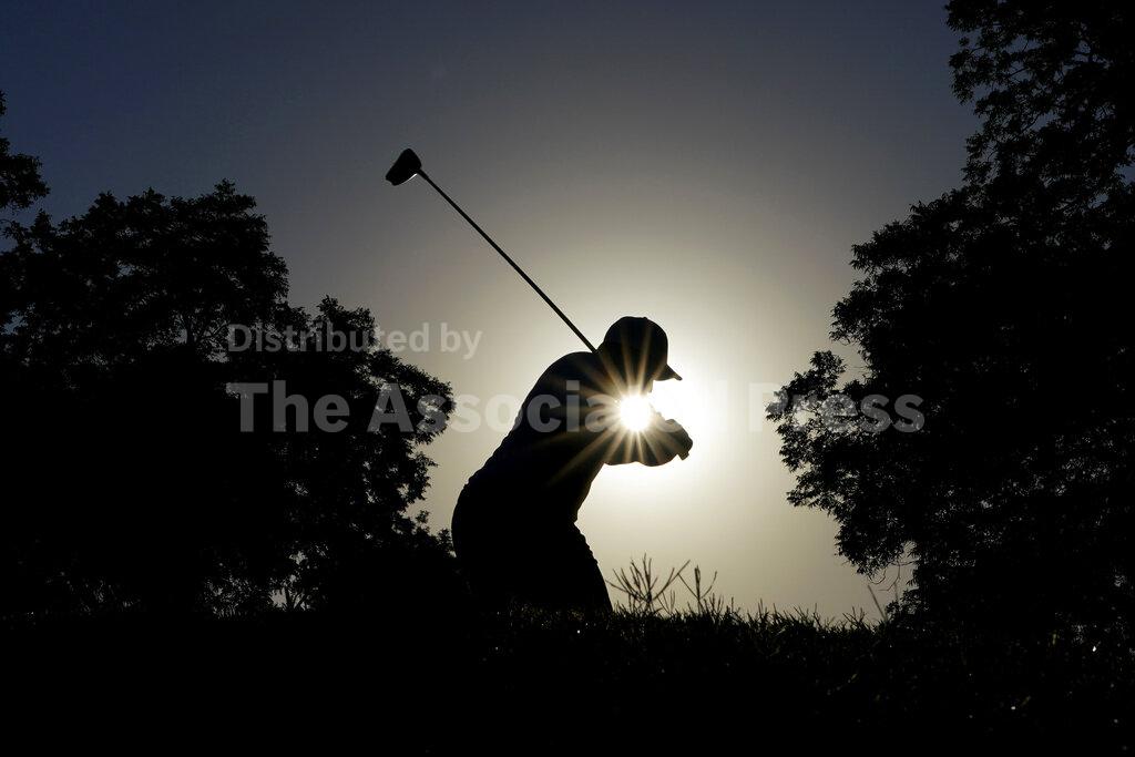 FILE - In this June 12, 2020, file photo, Harold Varner III tees off at the 11th hole during the second round of the Charles Schwab Challenge golf tournament at the Colonial Country Club in Fort Worth, Texas. The photo was part of a series of images by photographer David J. Phillip which won the Thomas V. diLustro best portfolio award for 2020 given out by the Associated Press Sports Editors during their annual winter meeting. (AP Photo/David J. Phillip, File)