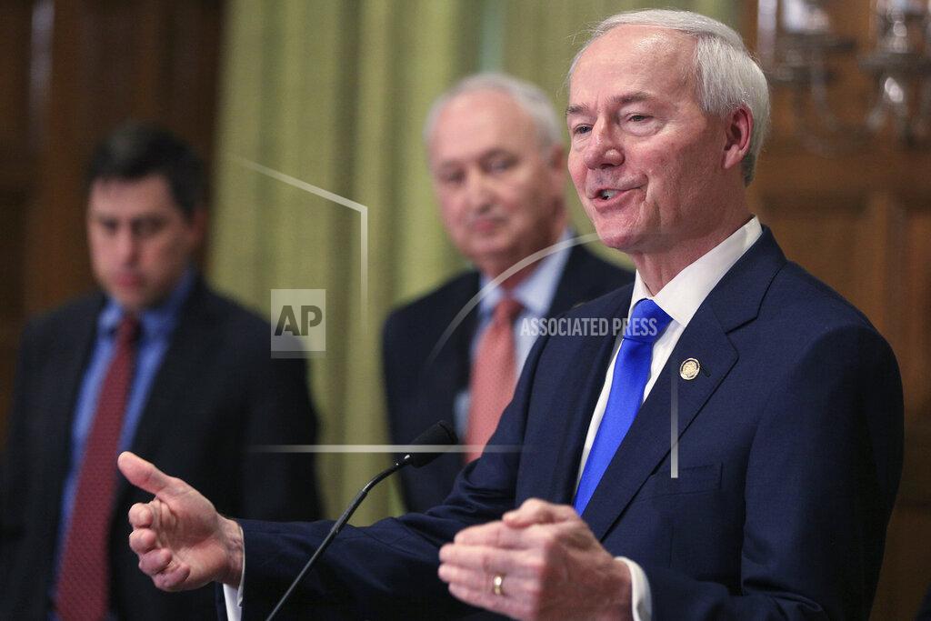 FILE - In this March 23, 2020 file photo, Gov. Asa Hutchinson, right, speaks in Little Rock Ark. Hutchinson says he's not ready to further ease restrictions on businesses as the number of coronavirus cases in the state continue to spike. Hutchinson on Thursday, June 25, 2020, said Arkansas' plans to further lift restrictions remains on pause after neighboring Texas halted its aggressive reopening of businesses. (Staton Breidenthal/The Arkansas Democrat-Gazette via AP File)