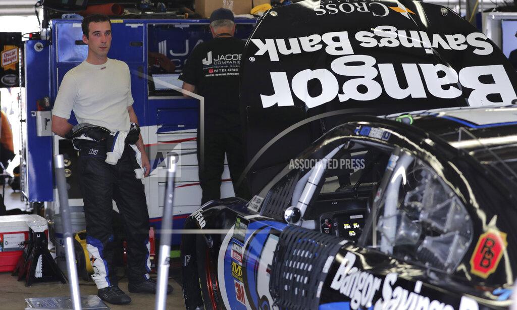 Charles Krupa Austin Theriault sheds a layer of his fire suit his garage following a NASCAR Cup Series auto race practice at New Hampshire Motor Speedway in Loudon, N.H., Saturday, July 20, 2019. (AP Photo/Charles Krupa)
