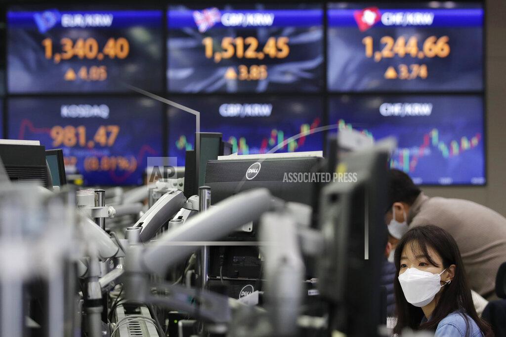 Lee Jin-Man A currency trader watches computer monitors near the screens showing the foreign exchange rates at the foreign exchange dealing room in Seoul, South Korea, Friday, Jan. 22, 2021. Asian stock markets retreated Friday after a resurgence of coronavirus infections in China and a rise in cases in Southeast Asia.(AP Photo/Lee Jin-man)