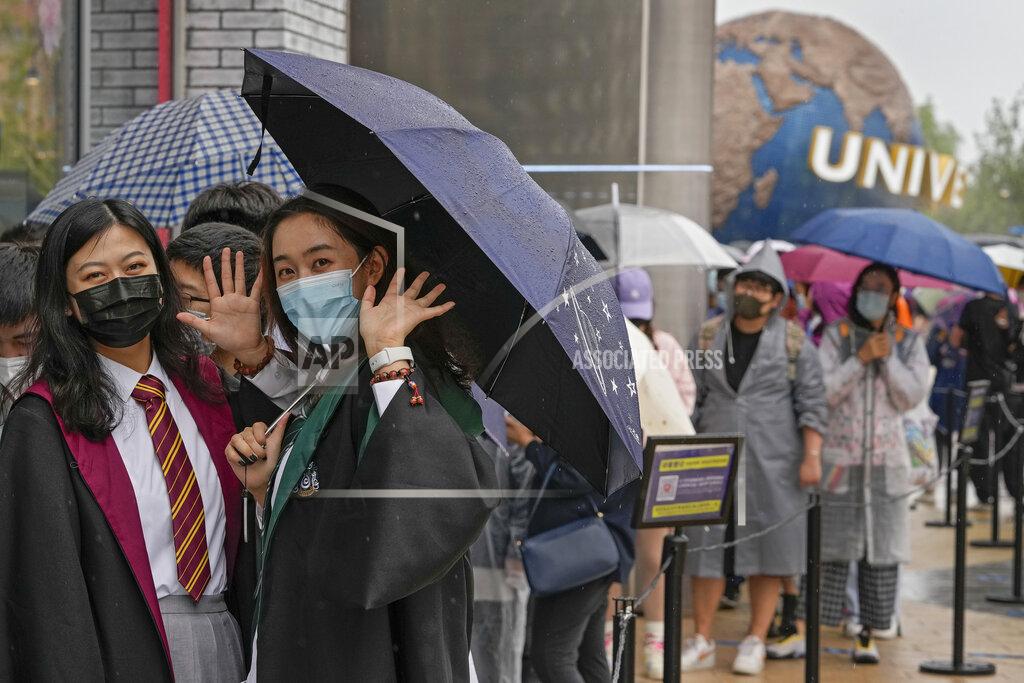 Andy Wong Women wearing face masks to help protect themselves from coronavirus wave as they line-up to enter a merchandise store at the Universal Studios Beijing in Beijing, Monday, Sept. 20, 2021. Thousands of people brave the rain visit to the newest location of the global brand of theme parks which officially opens on Monday. (AP Photo/Andy Wong)