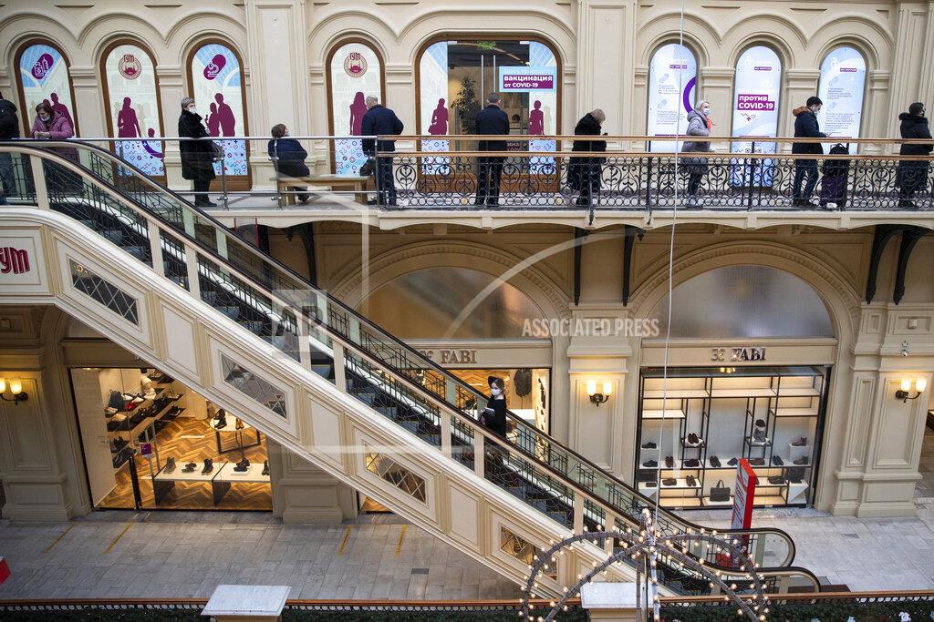 Pavel Golovkin People queue to get a shot of Russia's Sputnik V coronavirus vaccine at a vaccination center in GUM State Department store in Moscow, Russia, Wednesday, Jan. 20, 2021. Russia started a mass coronavirus vaccination campaign on Monday. (AP Photo/Pavel Golovkin)