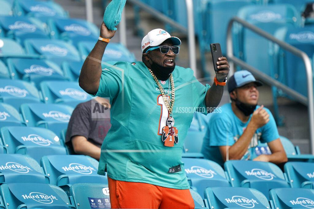 Wilfredo Lee A Miami Dolphins fan cheers after the team scores a touchdown, during the first half of an NFL football game against the Buffalo Bills, Sunday, Sept. 20, 2020 in Miami Gardens, Fla. (AP Photo/Wilfredo Lee)