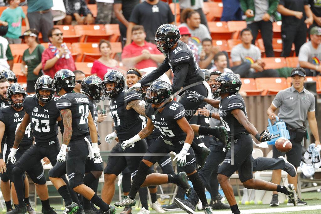 Marco Garcia The Hawaii bench celebrates after Hawaii defensive back Kai Kaneshiro (24) intercepted an Arizona pass during the first quarter of an NCAA college football game Saturday, Aug. 24, 2019, in Honolulu. (AP Photo/Marco Garcia)