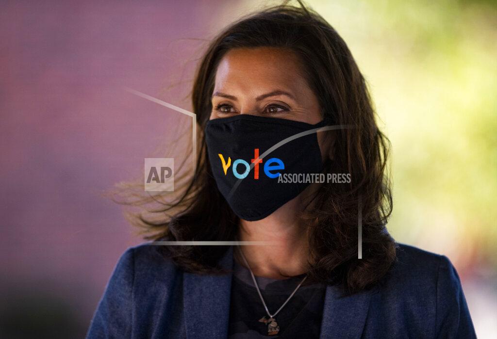 Michigan Gov. Gretchen Whitmer wears a mask with the word "vote" displayed on the front during a roundtable discussion on healthcare, Wednesday Oct. 7, 2020, in Kalamazoo, Mich. The arrest of a group of anti-government vigilantes in a kidnapping plot against Michigan Gov. Gretchen Whitmer presents a new twist in the 2020 political fight for the battleground state. (Nicole Hester/Ann Arbor News via AP)/