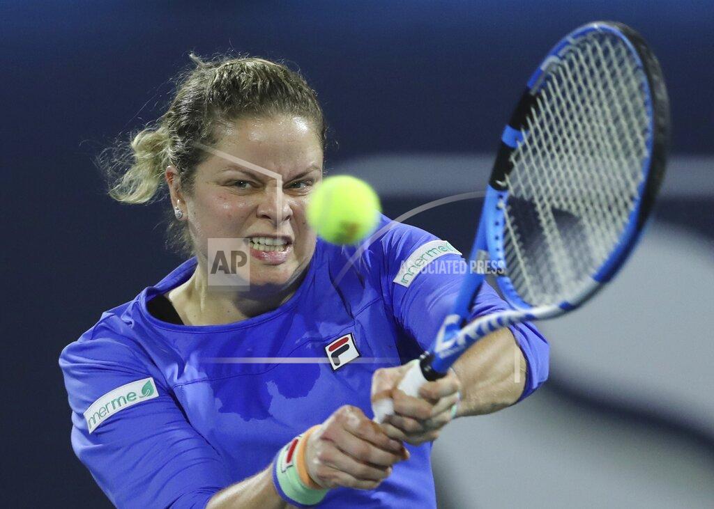Kamran Jebreili FILE - In this Feb. 17, 2020, file photo, Belgium's Kim Clijsters returns the ball to Spain's Gabrine Muguruza during a match of the Dubai Duty Free Tennis Championship in Dubai, United Arab Emirates. Any World TeamTennis player or coach who tests positive for COVID-19 when arriving for the three-week 2020 season will be dropped from the league without pay. The health plan released Tuesday, June 16, 2020, by the WTT for its matches starting July 12 at The Greenbrier in West Virginia also calls for two daily temperature checks for spectators, no ball kids, a chair umpire aided by electronic line-calling instead of line judges, and no high-fives or handshakes between opponents. The rosters announced for the WTT's nine teams include Grand Slam title winners Kim Clijsters, Sloane Stephens, Sofia Kenin and the Bryan brothers. (AP Photo/Kamran Jebreili, File)