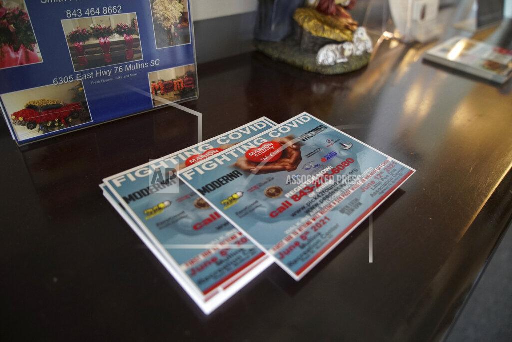 Allen G. Breed Cards promoting COVID-19 vaccination sit on a table inside Troy's Funeral Home in Mullins, S.C., on Sunday, May 23, 2021. In the summer of 2020, both William Penn Troy Sr. and his son were diagnosed and hospitalized with COVID. The elder Troy never returned home. And two weeks after his father’s burial, Shawn Troy presided over the first funeral without him. (AP Photo/Allen G. Breed)