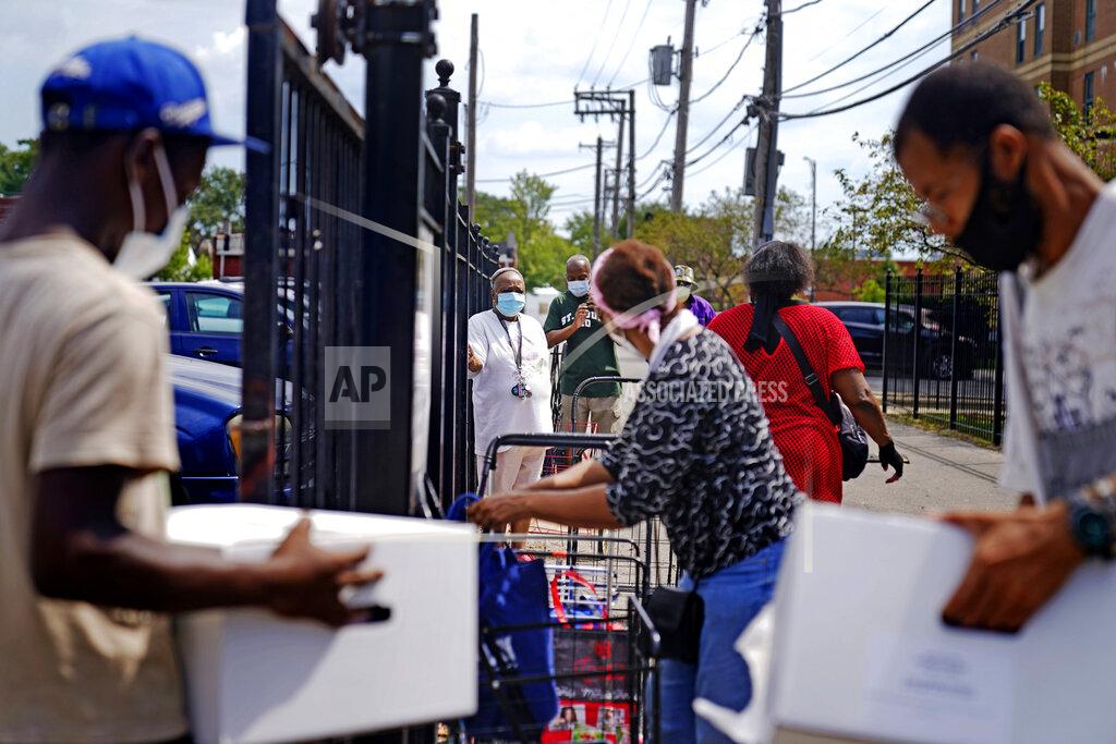 David Goldman Residents line up at a food distribution site at St. Sabina Catholic Church in the Auburn Gresham neighborhood in Chicago, Thursday, Aug. 27, 2020. In the neighborhood, many of those working survive paycheck-to-paycheck, and they've suffered, too, amid furloughs and job cuts. Food pantries have popped up and long lines of the newly unemployed wait for food donations. (AP Photo/David Goldman)