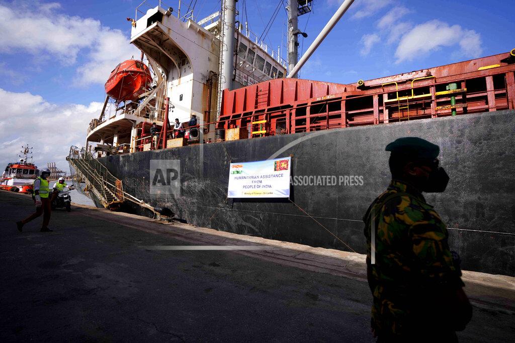 Eranga Jayawardena A police command stands by a ship that carried emergency supplies granted as humanitarian aid by Indian government to Sri Lankan people at a port in Colombo, Sri Lanka, Sunday, May 22, 2022. The consignment, which consists of 9,000 MT of rice, 50 MT of milk powder and more than 25 MT of drugs and other medical supplies. (AP Photo/Eranga Jayawardena)