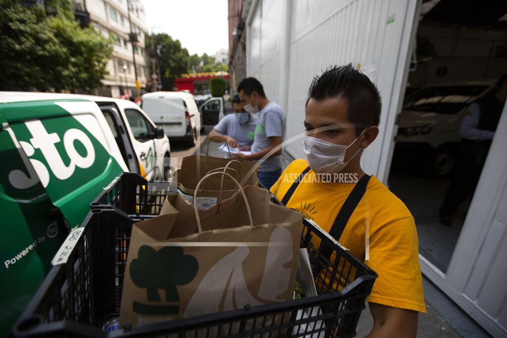 Fernando Llano A worker loads groceries outside the storage area of Justo, an online supermarket in Mexico City, Friday, April 24, 2020. Justo was founded just one year ago as Mexico's first online only grocer, and in the wake of the new coronavirus pandemic, sales have soared to record levels. (AP Photo/Fernando Llano)