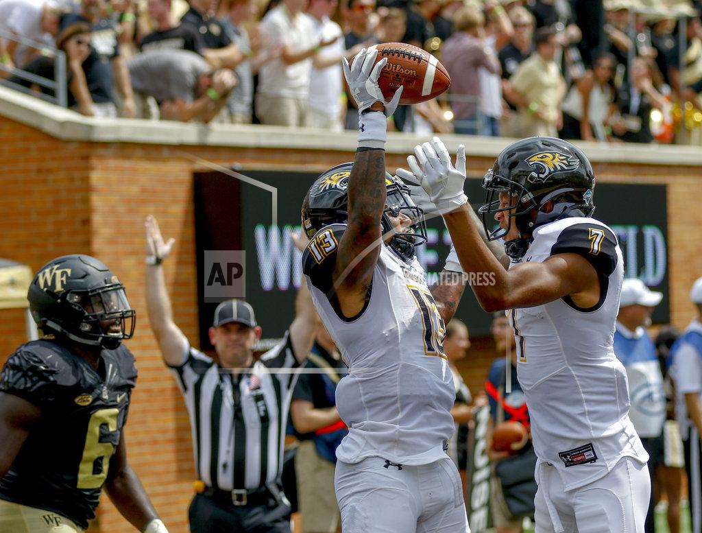 Nell Redmond Towson running back Shane Simpson, left, celebrates with teammate Jabari Greenwood as Wake Forest defensive lineman Chris Calhoun looks on after Simpson scored a touchdown in the first half of a NCAA college football game in Winston-Salem, N.C., Saturday, Sept. 8, 2018. (AP Photo/Nell Redmond)