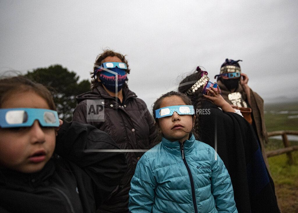 Esteban Felix A Mapuche Indigenous family uses special glasses to try and observe a total solar eclipse in Carahue, La Araucania, Chile, Monday, Dec. 14, 2020. The total eclipse was not visible from Carahue because of an overcast sky. (AP Photo/Esteban Felix)
