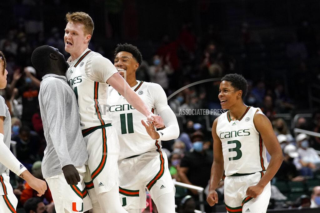 Lynne Sladky Miami forward Sam Waardenburg, second from left, reacts with guard Jordan Miller (11) and guard Charlie Moore (3) during the first half of an NCAA college basketball game against North Carolina, Tuesday, Jan. 18, 2022, in Coral Gables, Fla. (AP Photo/Lynne Sladky)