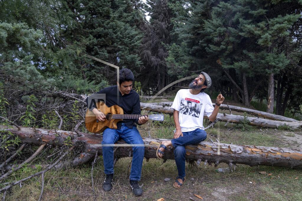 Dar Yasin Kashmiri musicians Sarfaraz Javid, right, and Mohsin Hassan Bhat Jam on the outskirts of Srinagar, Indian Kashmir, June 17, 2022. Musicians and artists in Kashmir are ordinary in life, each clutching onto the lived experiences of growing up in one of the world's most militarized zones that has known little but conflict for decades. But together, they embody a new form of music, a blend of progressive rock and hip hop that is an assertive expression of the region's political and cultural aspirations. (AP Photo/Dar Yasin)