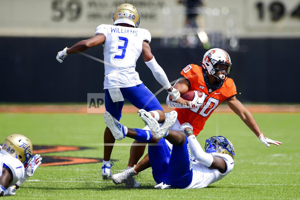 Brody Schmidt Oklahoma state Chuba Hubbard (30) is brought tackled by Tulsa defenders Cristian Williams (3) and Kenfarin Ray (1) in the second half of an NCAA college football game Saturday, Sept. 19, 2020, in Stillwater, Okla. (AP Photo/Brody Schmidt)