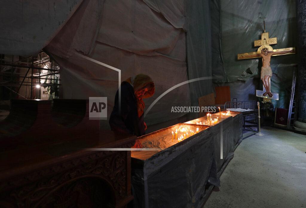 Darko Vojinovic FILE - In this Thursday, April 16, 2020 file photo, a woman lights candles after the service in the St. Sava temple, the largest Orthodox church in the Balkan regions in Belgrade, Serbia. Serbia's president Aleksandar Vucic has cancelled his party's pre-election rallies and officials in Bosnia, Macedonia and Albania are appealing on citizens to respect protection measures after relaxation of rules against the new coronavirus led to a recent spike in cases in the Balkan countries. (AP Photo/Darko Vojinovic, File)