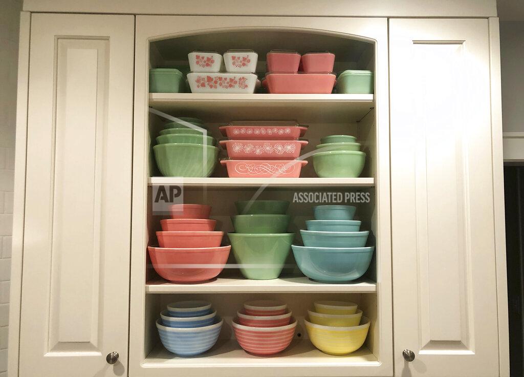 Lauren Mccullough Vintage pieces of Pyrex and Fire-King, as well as jadeite glass appear in a kitchen cupboard in Lynbrook, N.Y. Vintage kitchenware is back in style -– pieces from the mid-20th century painted with flowers, bright colors, and specific functions, such as bracketed chip and dip bowls or four-piece refrigerator storage sets. (Lauren McCullough via AP)