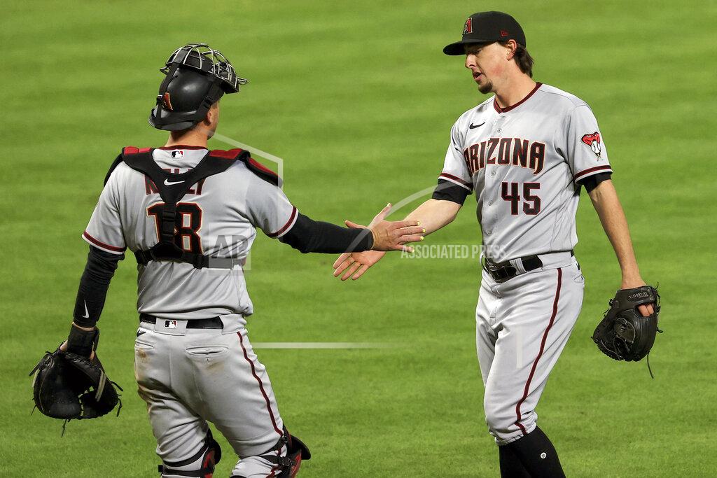 Aaron Doster Arizona Diamondbacks' Carson Kelly, left, celebrates with Taylor Clarke, right, after the final out of the tenth inning of a baseball game against the Cincinnati Reds, Wednesday, April 21, 2021. The Diamondbacks won 8-5. (AP Photo/Aaron Doster)