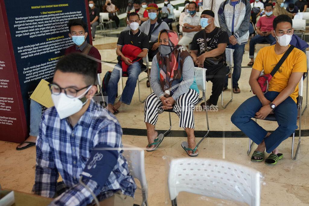 Dita Alangkara People wait for health screenings required before they receive the Sinovac vaccine for COVID-19 during a mass vaccination in Jakarta, Indonesia, Monday, June 21, 2021. Indonesia's president ordered authorities to speed up the country's vaccination campaign as the World Health Organization warned of the need to increase social restrictions in the country amid a fresh surge of coronavirus infections caused by worrisome variants. (AP Photo/Dita Alangkara)