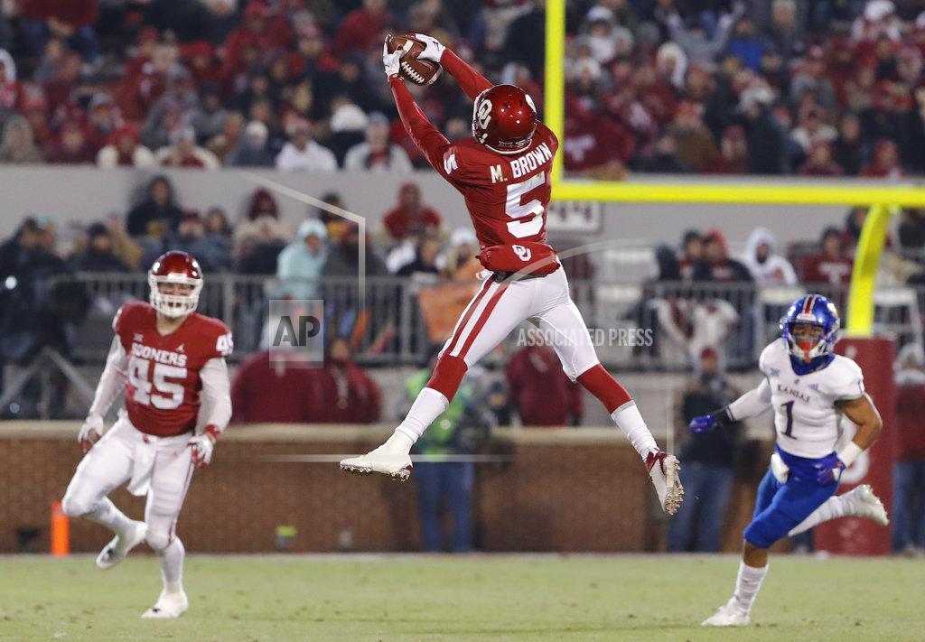 Alonzo Adams Oklahoma wide receiver Marquise Brown (5) makes a catch as Kansas safety Bryce Torneden (1) and Oklahoma fullback Carson Meier (45) looks on during the second half of an NCAA college football game in Norman, Okla., Saturday, Nov. 17, 2018. Oklahoma won 55-40. (AP Photo/Alonzo Adams)