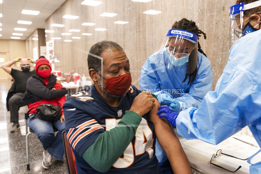 Jacquelyn Martin In this Thursday, Feb. 11, 2021, photo Peter Thomas, 58, of Washington, receives his second dose of the COVID-19 vaccine at a clinic at Howard University, in Washington. (AP Photo/Jacquelyn Martin)
