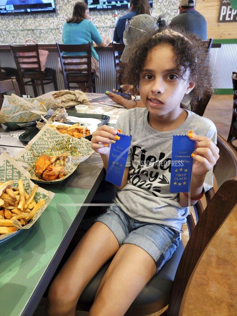 Uncredited In this image provided by Vincent Salazar, Layla Salazar poses with her first place ribbons from field day at her school, Robb Elementary School. Layla was one of the 19 children and their two teachers who were gunned down behind a barricaded door at Robb Elementary School in Uvalde, Texas. (Vincent Salazar via AP)